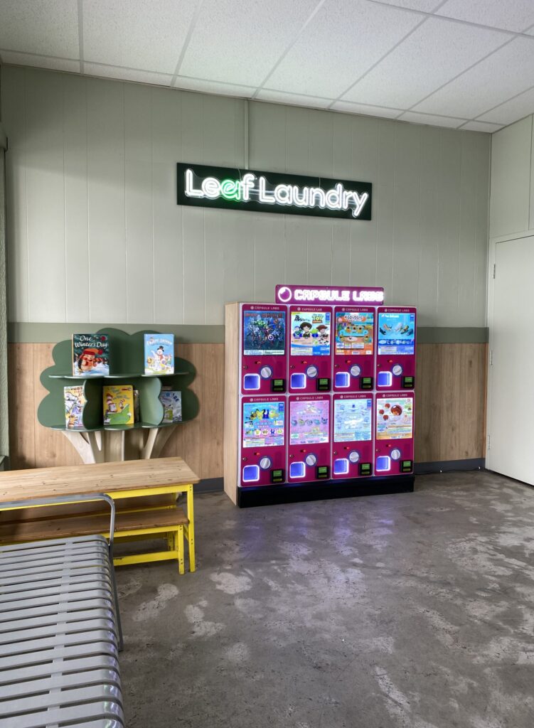 Bookshelf and toy machine in children's section at Leaf Laundry West Sacramento